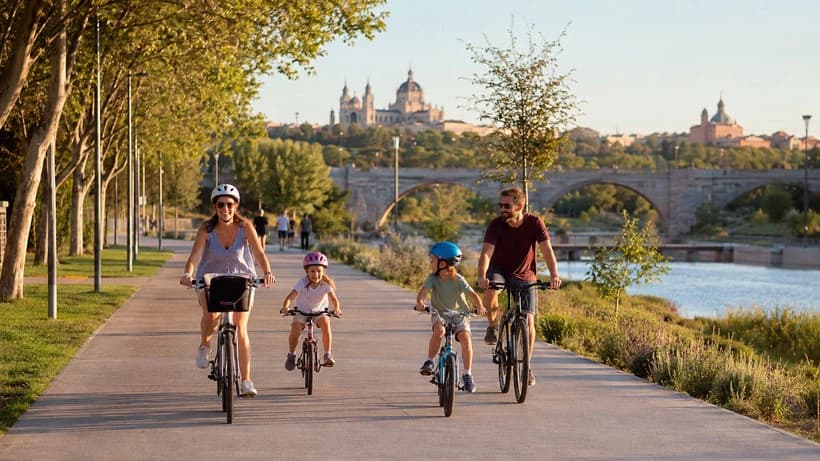 Familia paseando en bici por el Anillo Verde de Madrid Río con niños en una tarde de verano