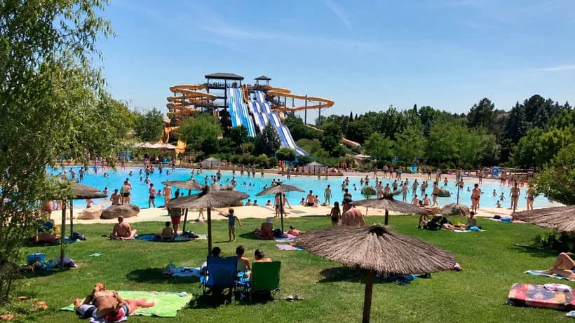 Niños bajando por un tobogán de agua en un parque acuático de Madrid en un día soleado